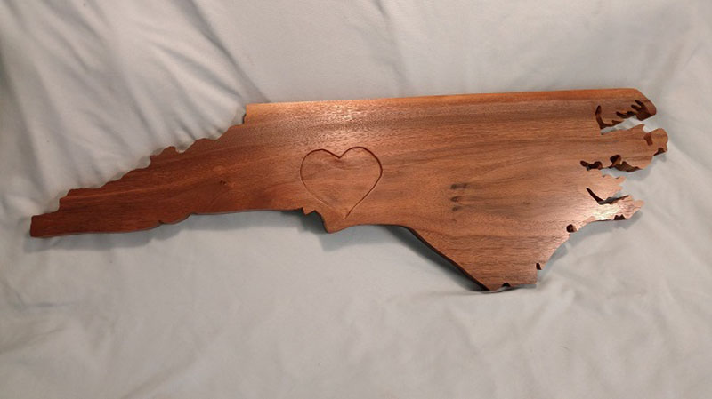 NC State outline with hand engraved heart on Charlotte created by customer Steve Fontaine using Walnut. 
